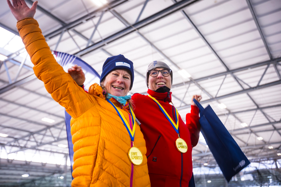 Två medaljörer firar efter en tävling i Long Track.