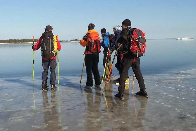 En grupp skridskoåkare står på spegelblank is